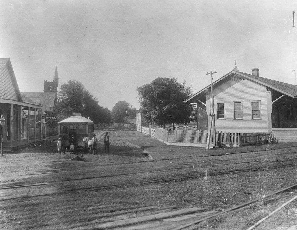 On Lower Third Street in Alexandria, Louisiana, a conductor on an early streetcar poses with children.
